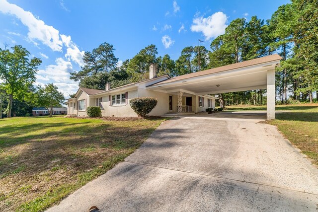 ranch-style home featuring a carport and a front yard