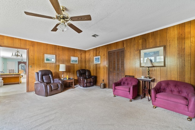 sitting room featuring light carpet, wood walls, and crown molding