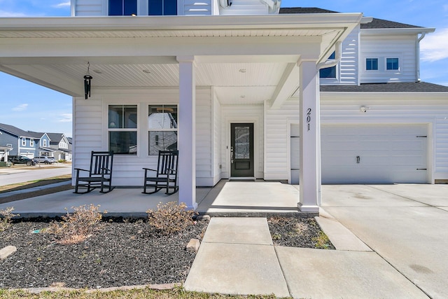 property entrance with concrete driveway, a garage, covered porch, and a shingled roof