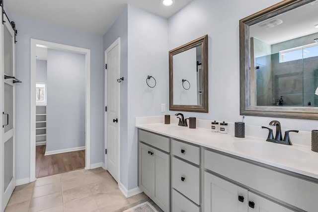 full bath with a sink, visible vents, double vanity, and a tile shower