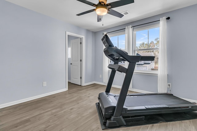 workout room featuring visible vents, baseboards, light wood-style flooring, and a ceiling fan