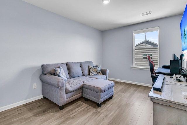 office with baseboards, visible vents, and light wood-type flooring