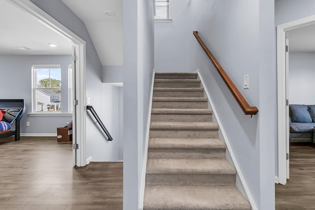 staircase featuring baseboards and wood finished floors