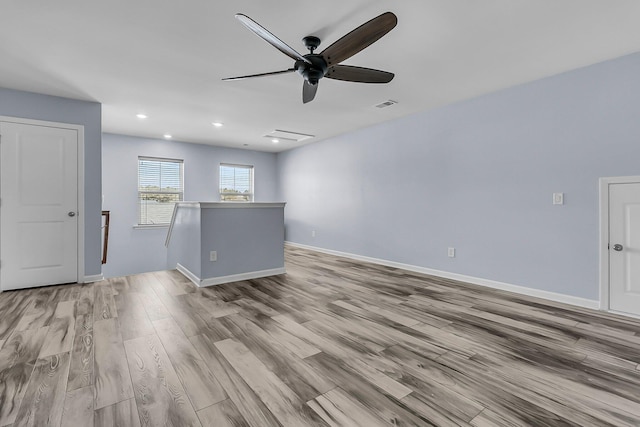 empty room featuring visible vents, baseboards, light wood-style floors, and a ceiling fan