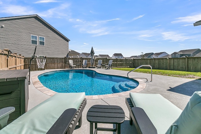 view of swimming pool with a fenced backyard, a residential view, a fenced in pool, and a patio