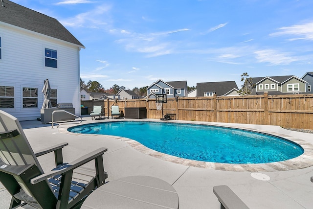 view of pool with a residential view, a patio, and a fenced backyard