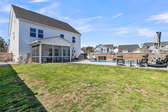 rear view of property with a patio, a lawn, a fenced backyard, and a sunroom