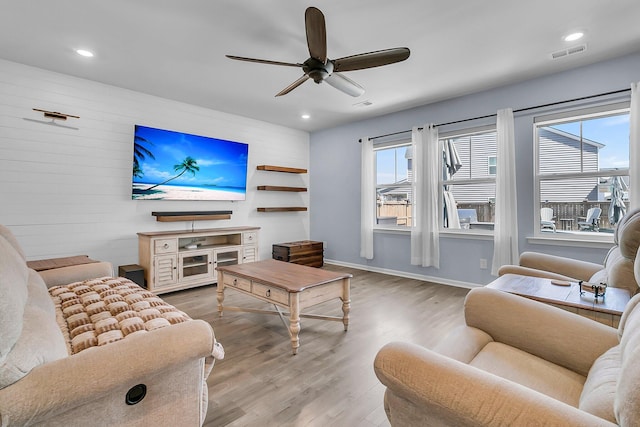 living room featuring ceiling fan, wood finished floors, visible vents, and a healthy amount of sunlight