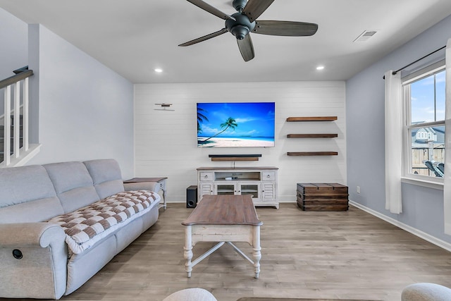 living area with visible vents, baseboards, and wood finished floors