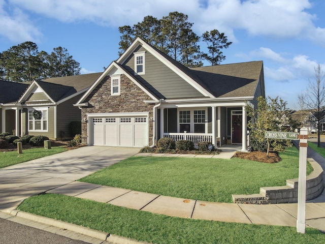 view of front of house featuring a porch, a garage, and a front yard