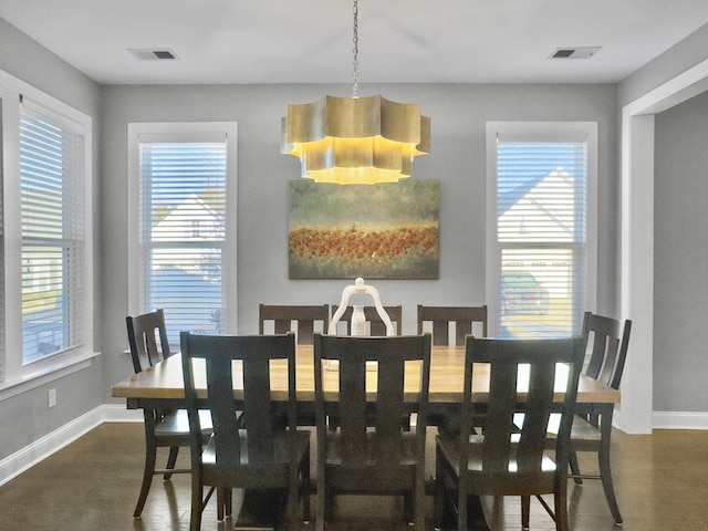 dining room featuring a healthy amount of sunlight and dark hardwood / wood-style flooring