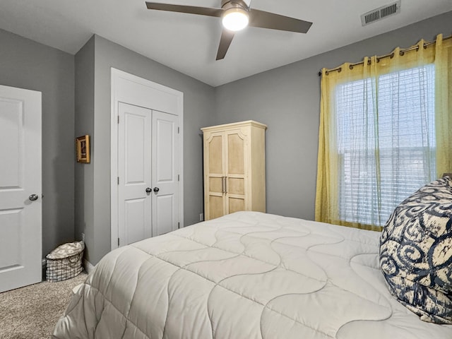 carpeted bedroom with ceiling fan and a closet