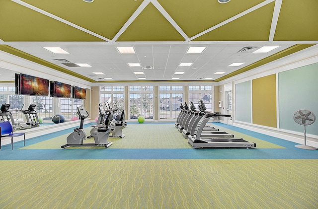 exercise room with crown molding, a paneled ceiling, and carpet