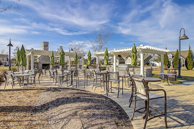 exterior space with an outdoor fireplace and a pergola