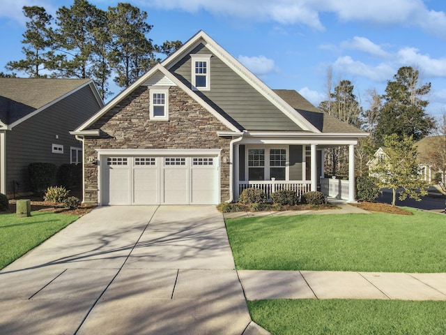 view of front of house featuring a garage, covered porch, and a front yard