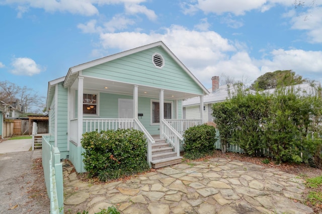 view of front facade with covered porch and fence