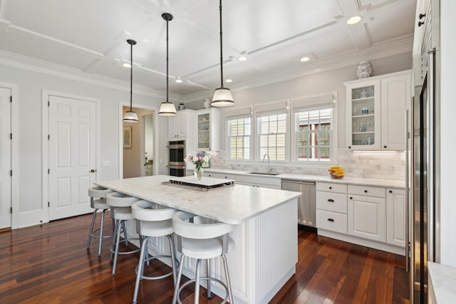 kitchen with white cabinets, stainless steel appliances, dark hardwood / wood-style floors, and a center island