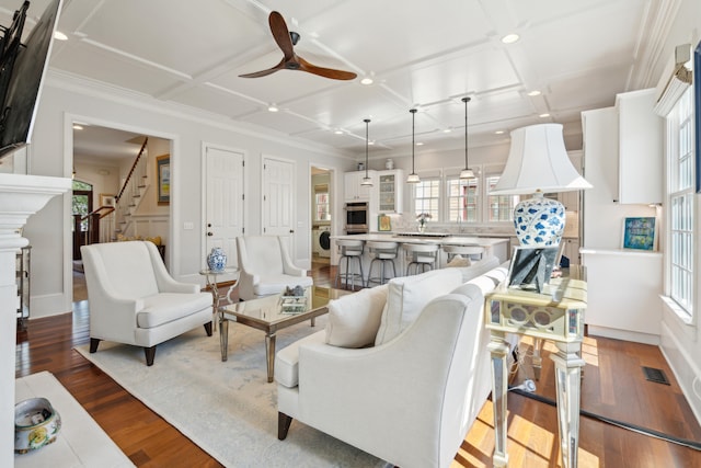 living room with wood-type flooring, crown molding, coffered ceiling, and ceiling fan