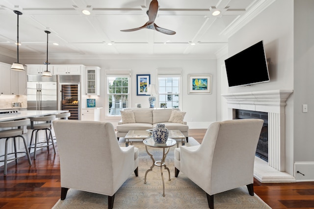 living room with ceiling fan, wine cooler, coffered ceiling, crown molding, and dark hardwood / wood-style flooring