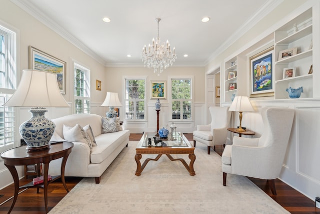 sitting room with hardwood / wood-style flooring, built in features, ornamental molding, and a chandelier