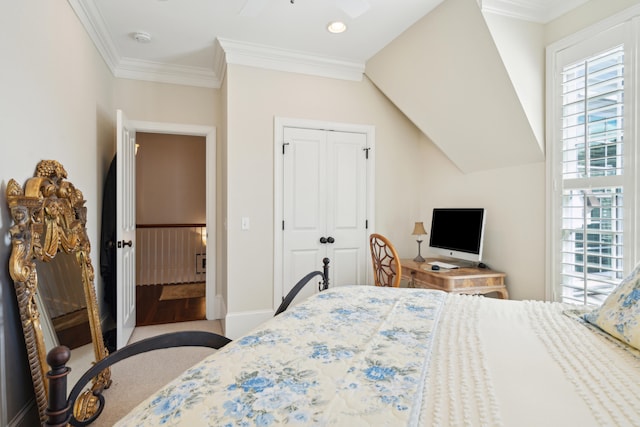 carpeted bedroom featuring ceiling fan, a closet, and ornamental molding