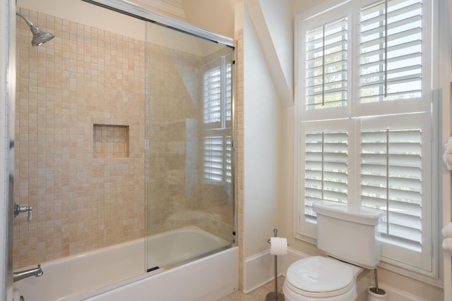 bathroom featuring enclosed tub / shower combo and toilet