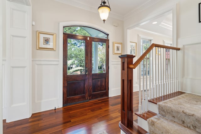 foyer entrance with ornamental molding, a wealth of natural light, french doors, and dark hardwood / wood-style flooring