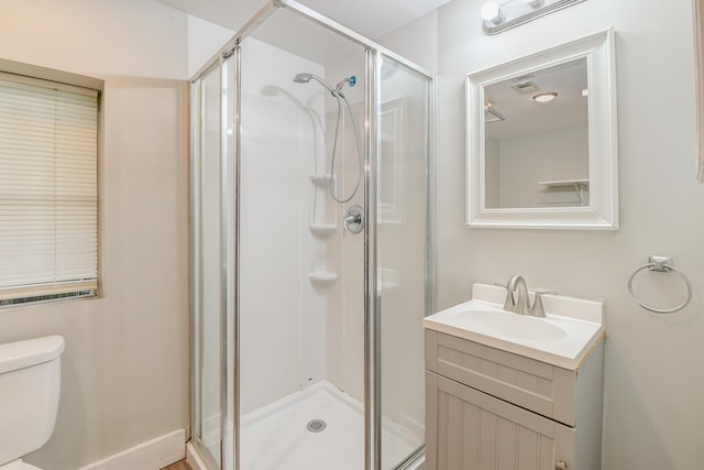 bathroom with vanity, a shower with shower door, and toilet