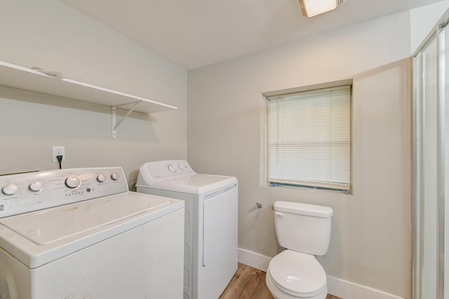 laundry room with light wood-type flooring and separate washer and dryer