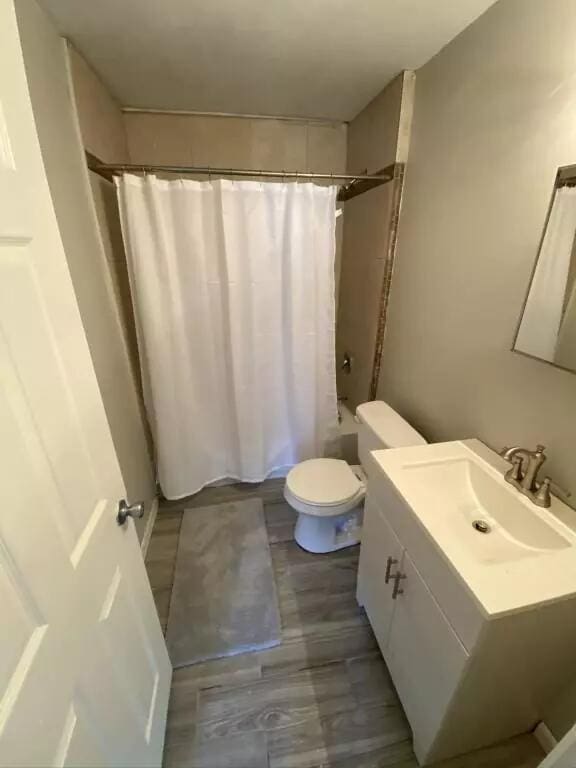 full bathroom with vanity, shower / tub combo, and toilet