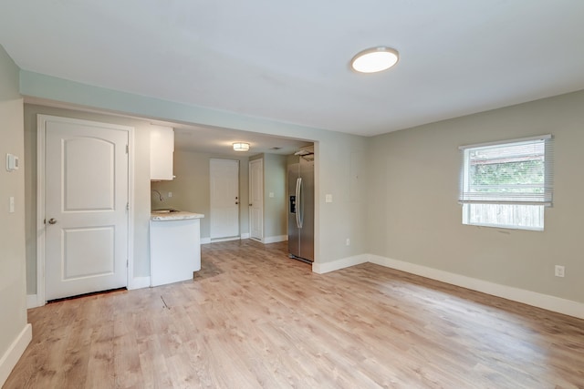 unfurnished room with light wood-type flooring and sink