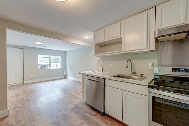 kitchen featuring appliances with stainless steel finishes, sink, white cabinetry, and light hardwood / wood-style flooring