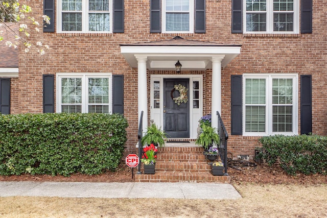 doorway to property featuring brick siding