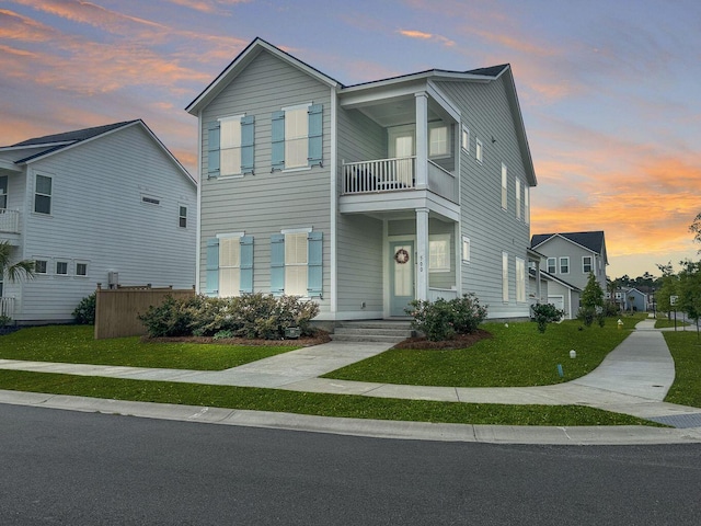 view of front of property with a balcony and a front lawn