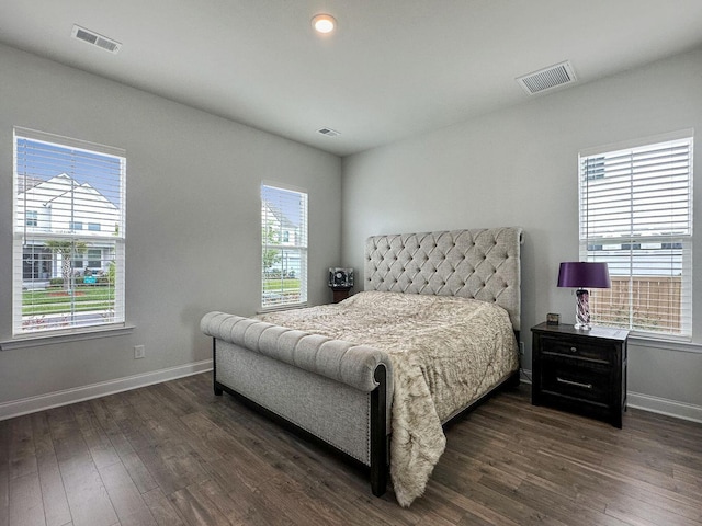 bedroom featuring dark wood-style flooring, visible vents, and multiple windows