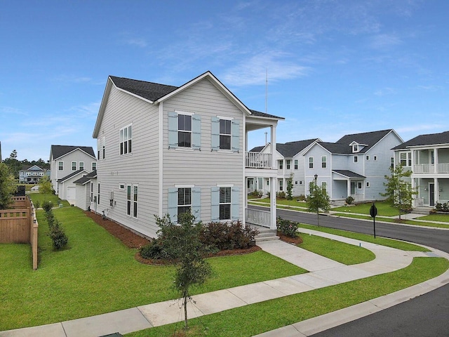 view of front of house with a front lawn, a balcony, and a residential view