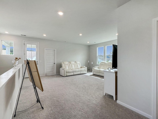 living room featuring recessed lighting, light carpet, visible vents, and baseboards