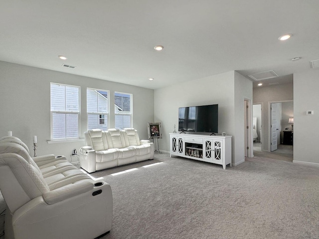 carpeted living area featuring baseboards, visible vents, and recessed lighting