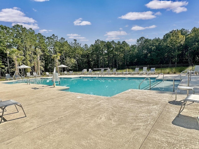 community pool featuring a patio area and fence