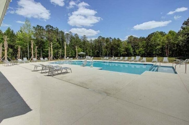 pool with a patio area and fence