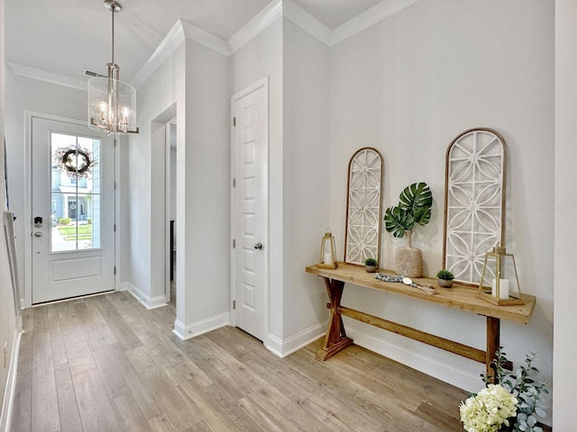 foyer with light wood-style flooring, baseboards, a chandelier, and ornamental molding