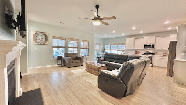 living room with ceiling fan and light wood-type flooring