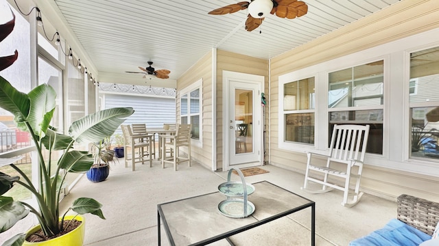 sunroom / solarium featuring ceiling fan and plenty of natural light