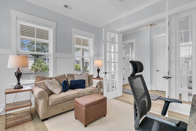 1182 Welcome Dr, Mount Pleasant, SC 29464 - office area with french doors, light wood finished floors, healthy amount of natural light, and wainscoting
