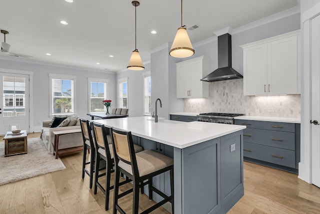 1182 Welcome Dr, Mount Pleasant, SC 29464 - kitchen featuring wall chimney exhaust hood, crown molding, gray cabinetry, tasteful backsplash, and range