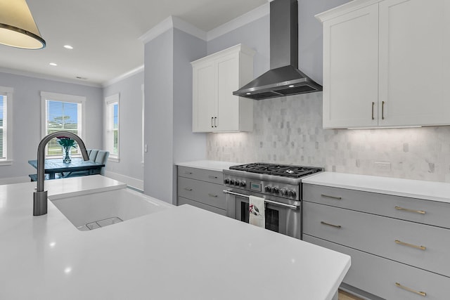 1182 Welcome Dr, Mount Pleasant, SC 29464 - kitchen featuring wall chimney exhaust hood, stainless steel stove, a sink, ornamental molding, and light countertops