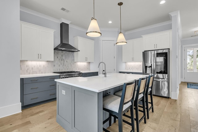 1182 Welcome Dr, Mount Pleasant, SC 29464 - kitchen featuring wall chimney range hood, stainless steel fridge, crown molding, gray cabinetry, and light countertops