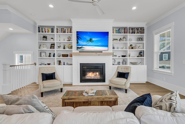 1182 Welcome Dr, Mount Pleasant, SC 29464 - living room with wood finished floors, built in shelves, a ceiling fan, a large fireplace, and recessed lighting