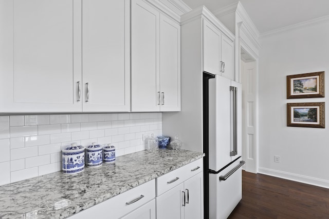 3998 Capensis Ln, Ravenel, SC 29470 - kitchen featuring freestanding refrigerator, ornamental molding, dark wood-type flooring, white cabinets, and light stone counters