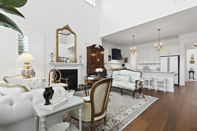 3998 Capensis Ln, Ravenel, SC 29470 - living area featuring a chandelier, dark wood-style flooring, a fireplace, a towering ceiling, and crown molding